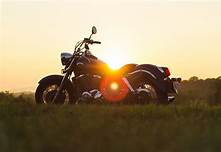 Image Depicts A Motorcycle With A Sunset Backround
